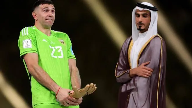 epa10373090 Argentina's goalkeeper Emiliano Martinez (L) poses after receiving the Golden Glove award as best goalkeeper of the tournament after the FIFA World Cup 2022 Final between Argentina and France at Lusail stadium, Lusail, Qatar, 18 December 2022.  EPA/Friedemann Vogel