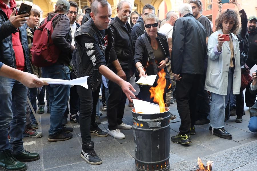 Bollette bruciate simbolicamente contro il caro energia a Bologna (foto Schicchi)