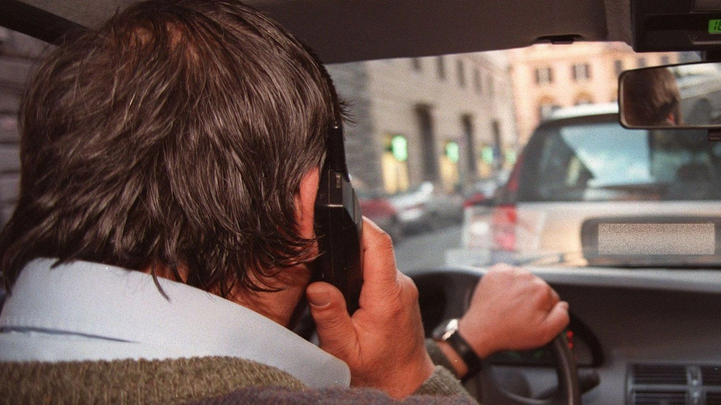 Un automobilista col telefonino in mano mentre è alla guida (Foto di repertorio Ansa)
