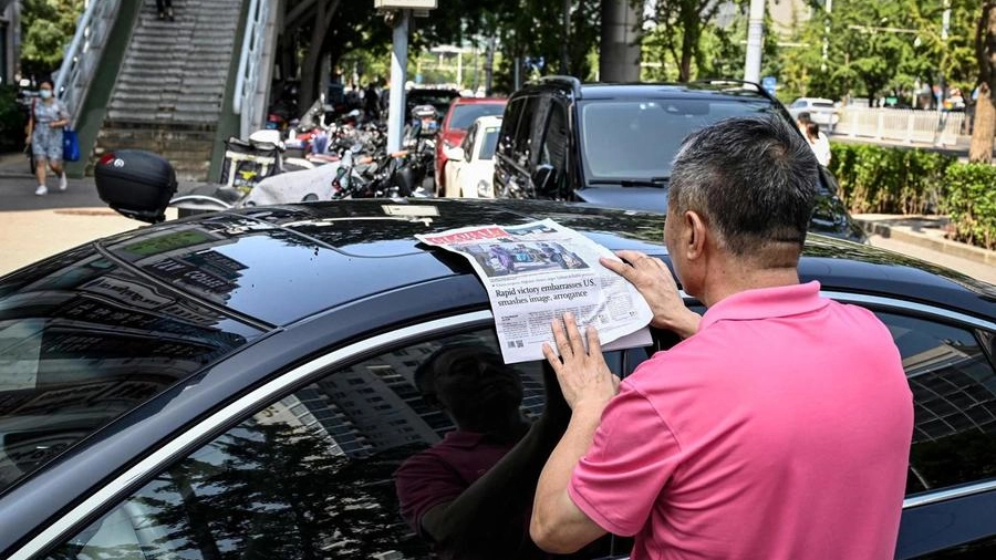 Afghanistan, un uomo cinese legge sul giornale la presa di Kabul (Ansa)