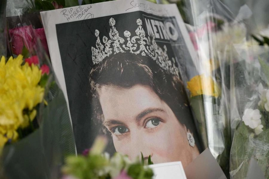 Una gigantografia di una giovane Elisabetta II tra i fiori lasciati in suo ricordo 