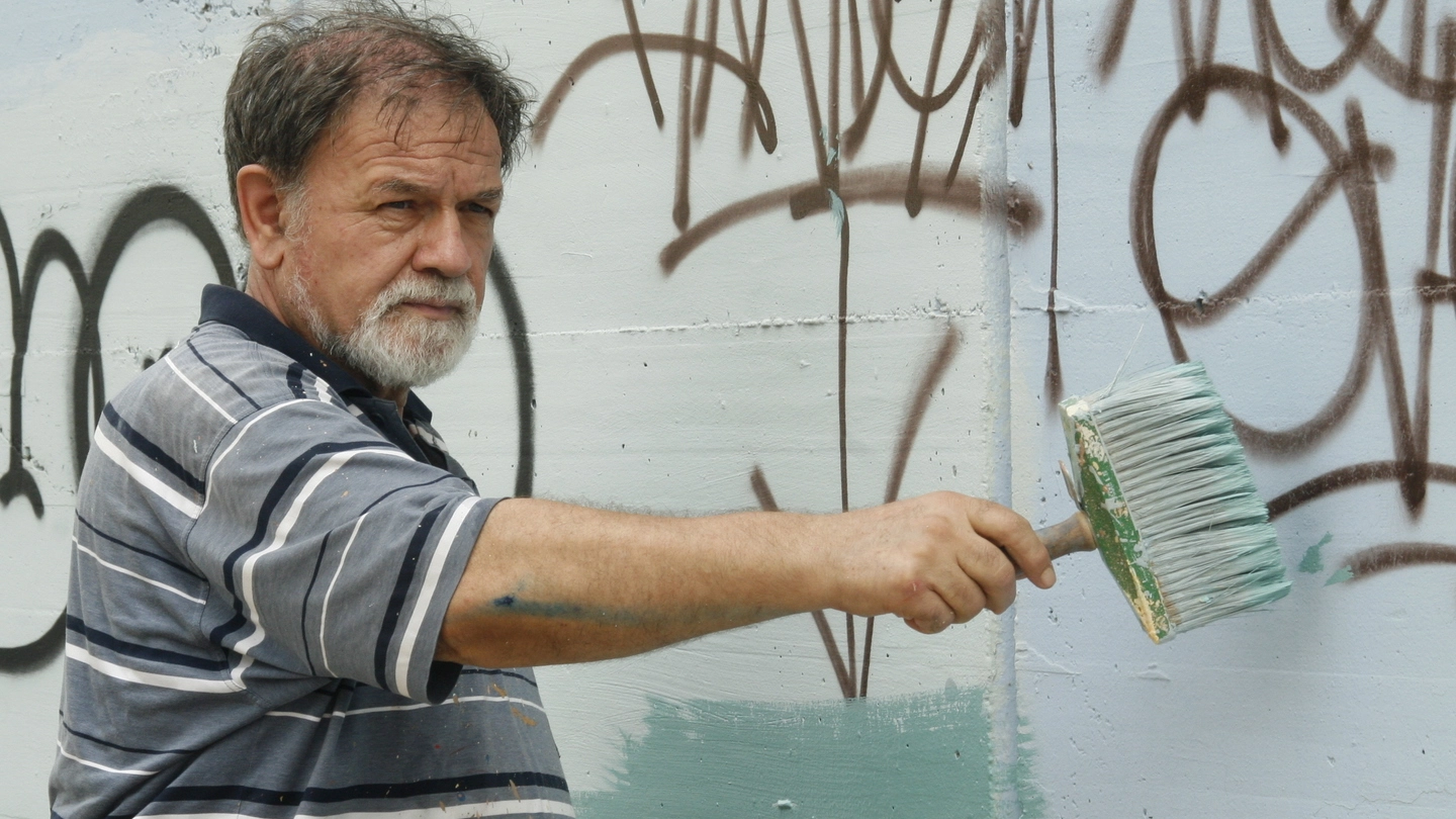 Ercole Toni mentre ripulisce le scritte dai muri a Modena