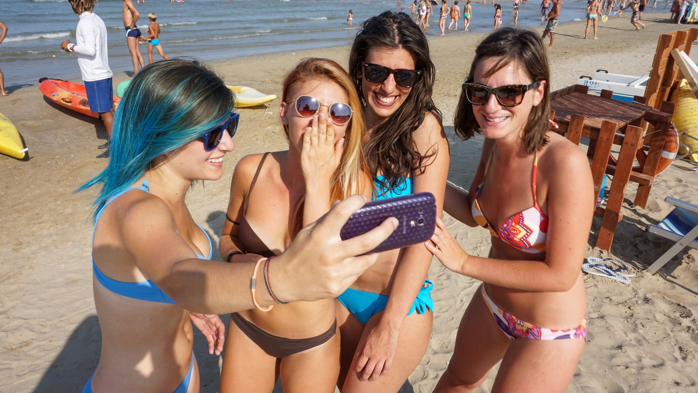 Ragazze che fanno selfie in spiaggia a Rimini