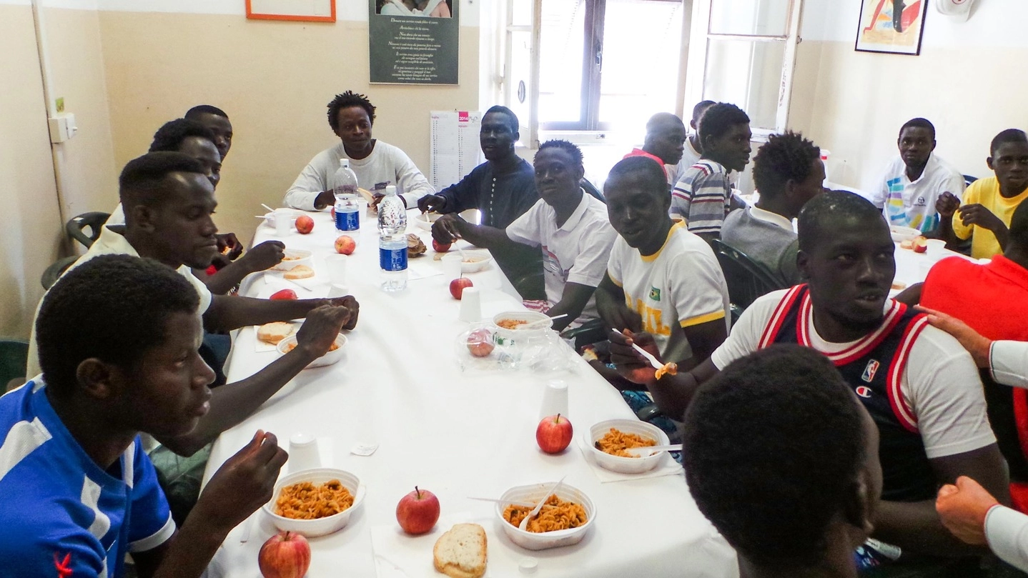 Alcuni profughi mentre mangiano in mensa