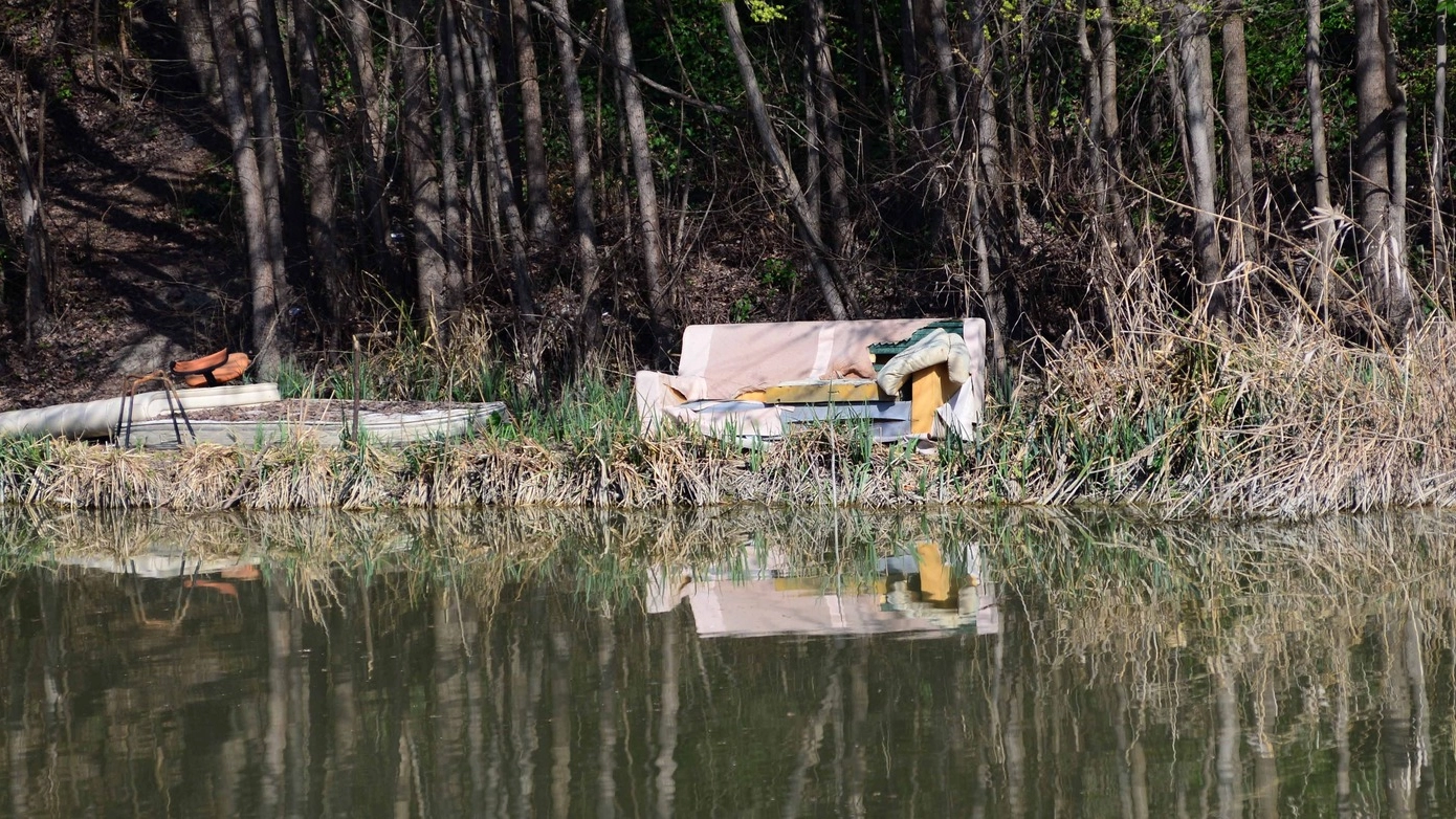 SALOTTO SULLA RIVA Un divano, un materasso e altri oggetti sulla riva del canale