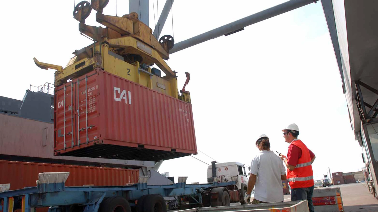 Lavoratori portuali impegnati nel carico e scarico dei container dalle navi