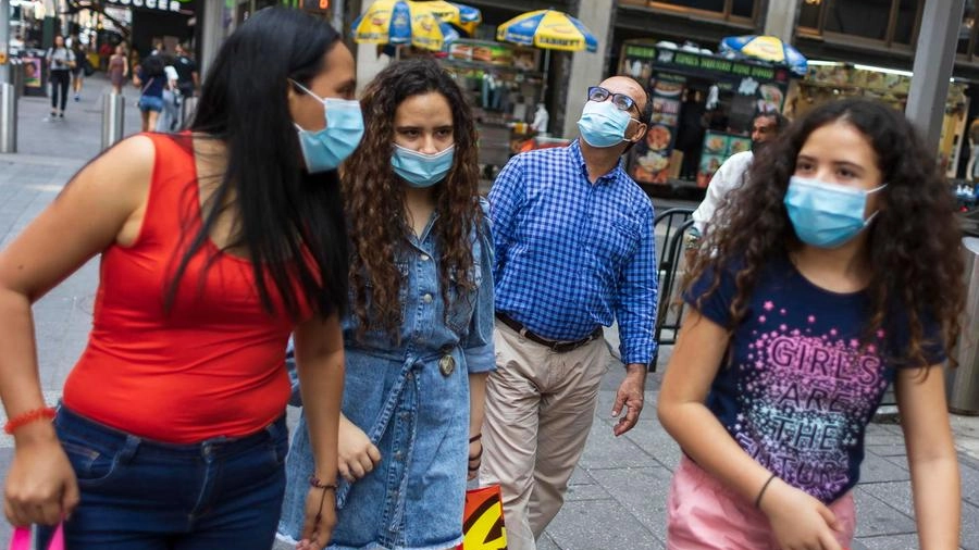 Gente con la mascherina per le strade di New York (Ansa)