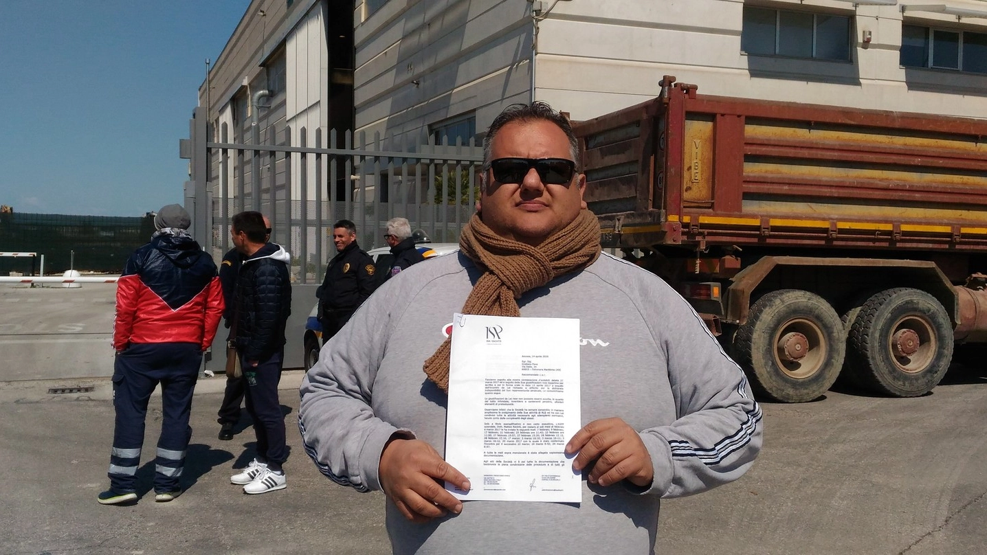 Emiliano Fava mostra la lettera di licenziamento ricevuta. E’ stato fotografato davanti alla sua azienda