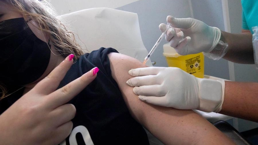 Una ragazza viene vaccinata (Ansa)