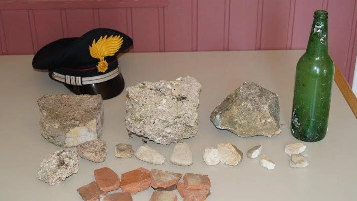 Le pietre e la bottiglia sequestrate dai carabinieri