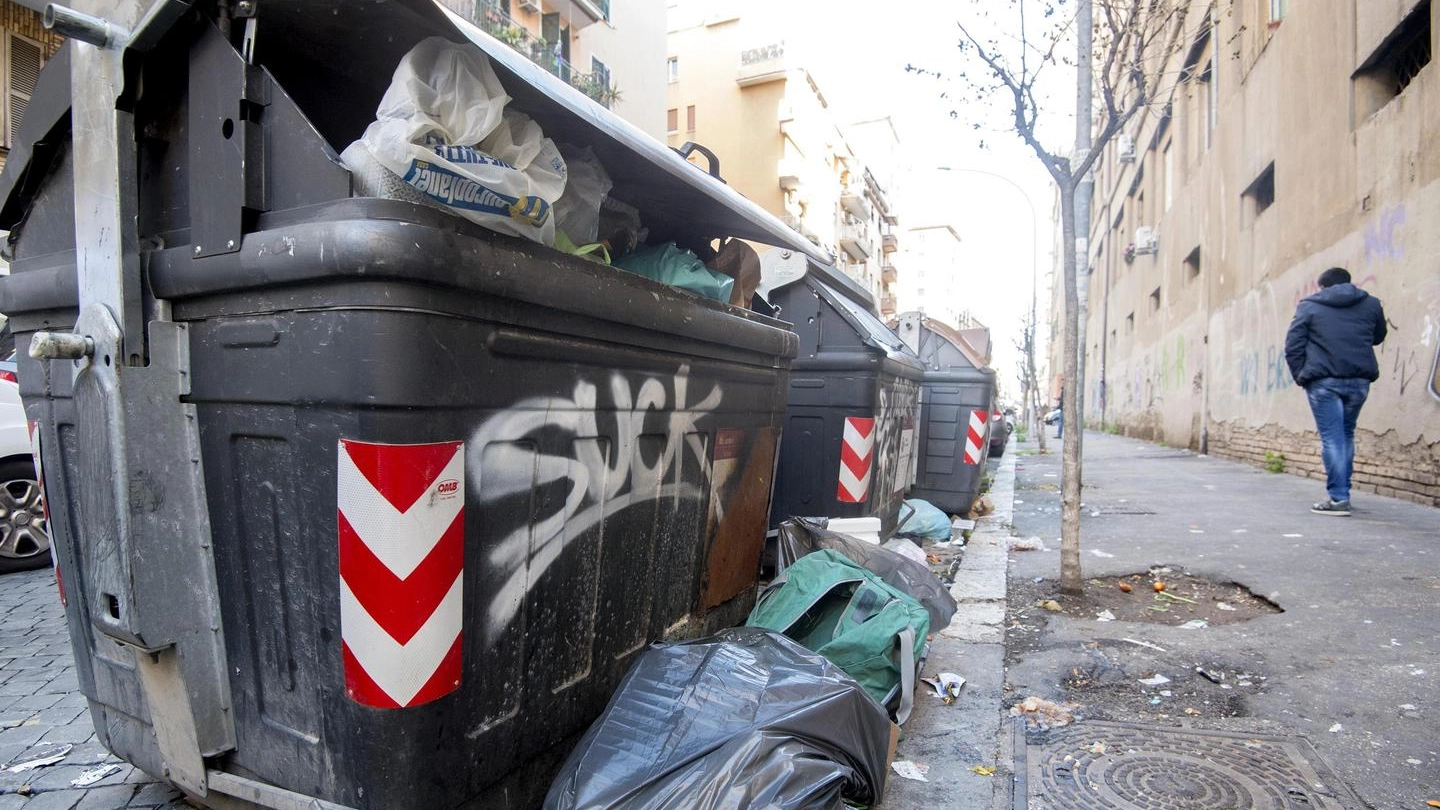 Un cassonetto pieno di rifiuti a Roma (Ansa)