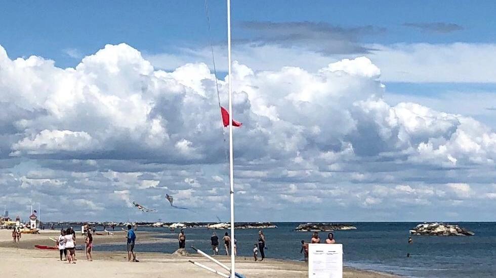 Bandiere a mezz'asta sulla spiaggia per la morte del bagnino
