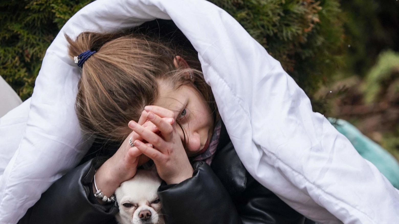 Una ragazza stringe il cane nel centro di distribuzione dei rifugiati ucraini a Korczowa 