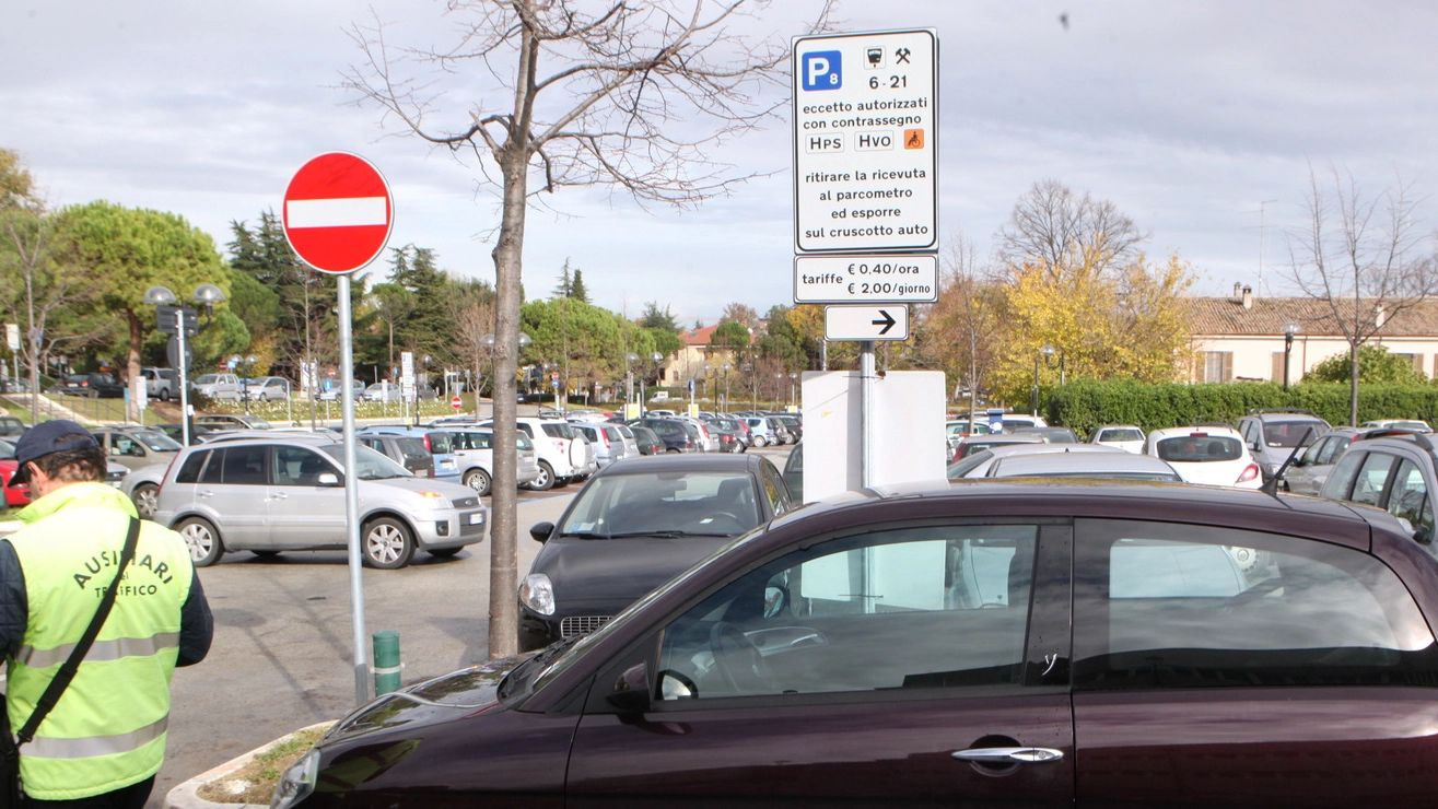 VERIFICA Un ausiliario della sosta controlla le auto parcheggiate nella zona dell’ospedale Bufalini (foto Luca Ravaglia)