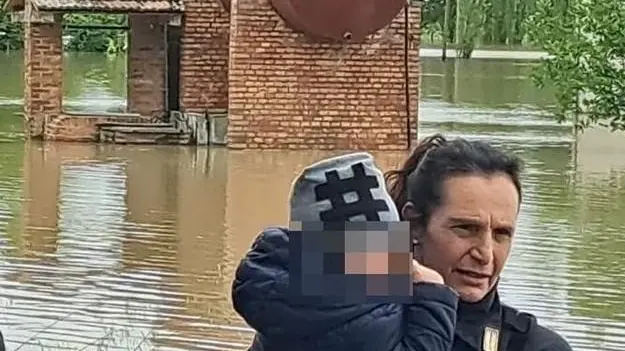 Una foto come simbolo  La poliziotta e il bimbo,  fuga dall’alluvione:  l’abbraccio commuove