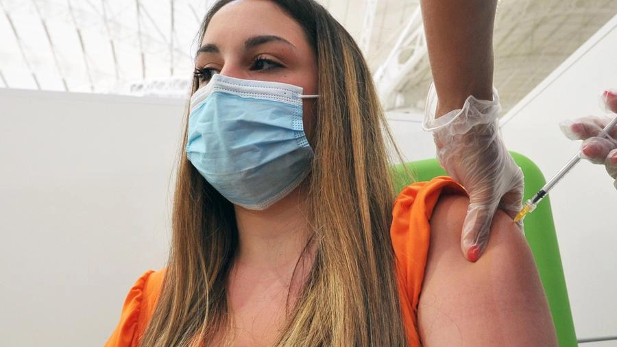 Una giovane si sottopono alla vaccinazione anti covid in un hub