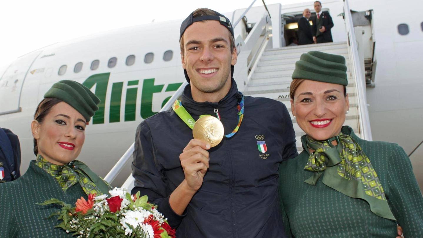Gregorio Paltrinieri atterra a Roma e posa con le hostess per una foto ricordo (Ansa)