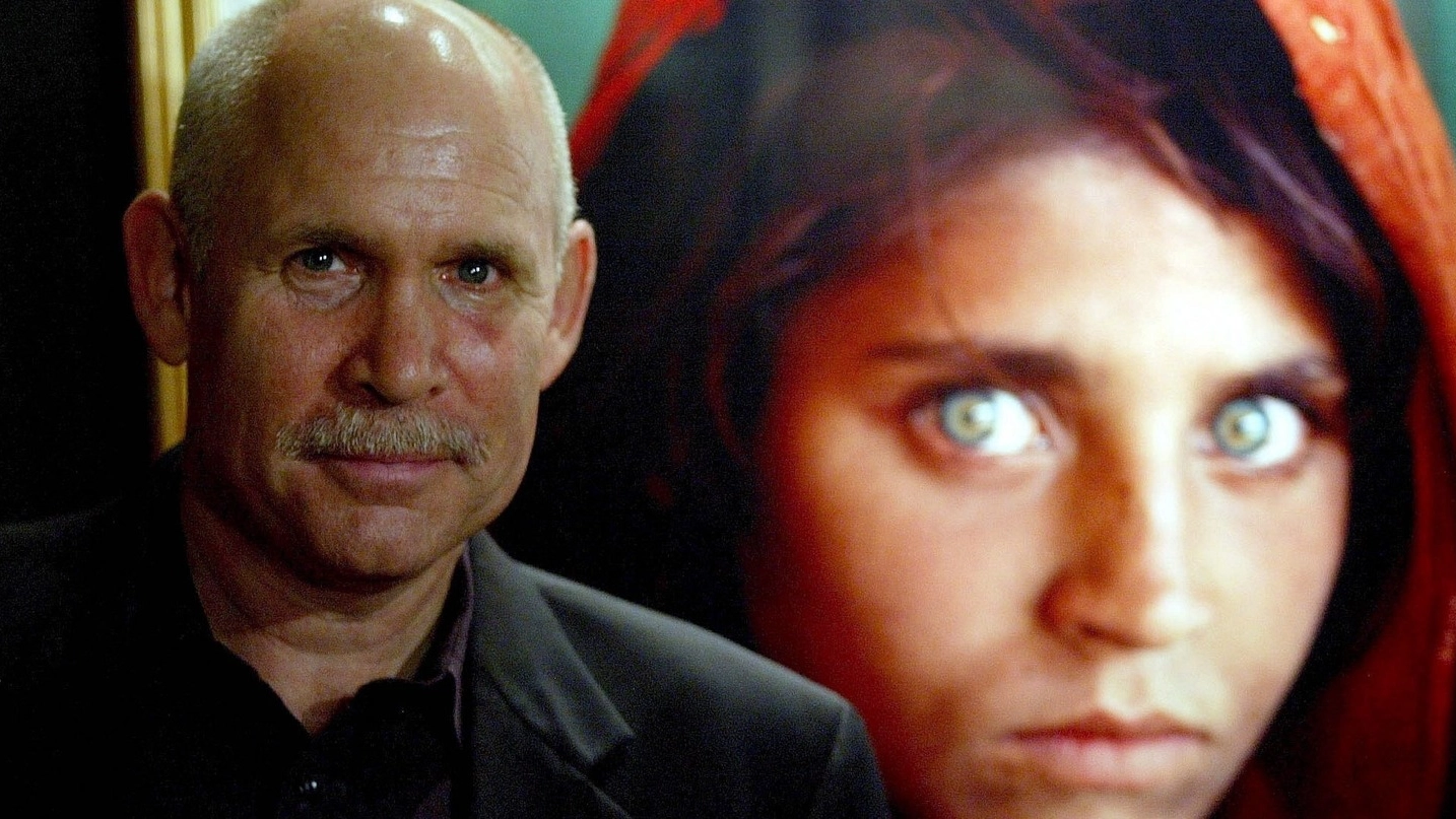Steve McCurry e una delle sue fotografie più famose (Foto Ansa)