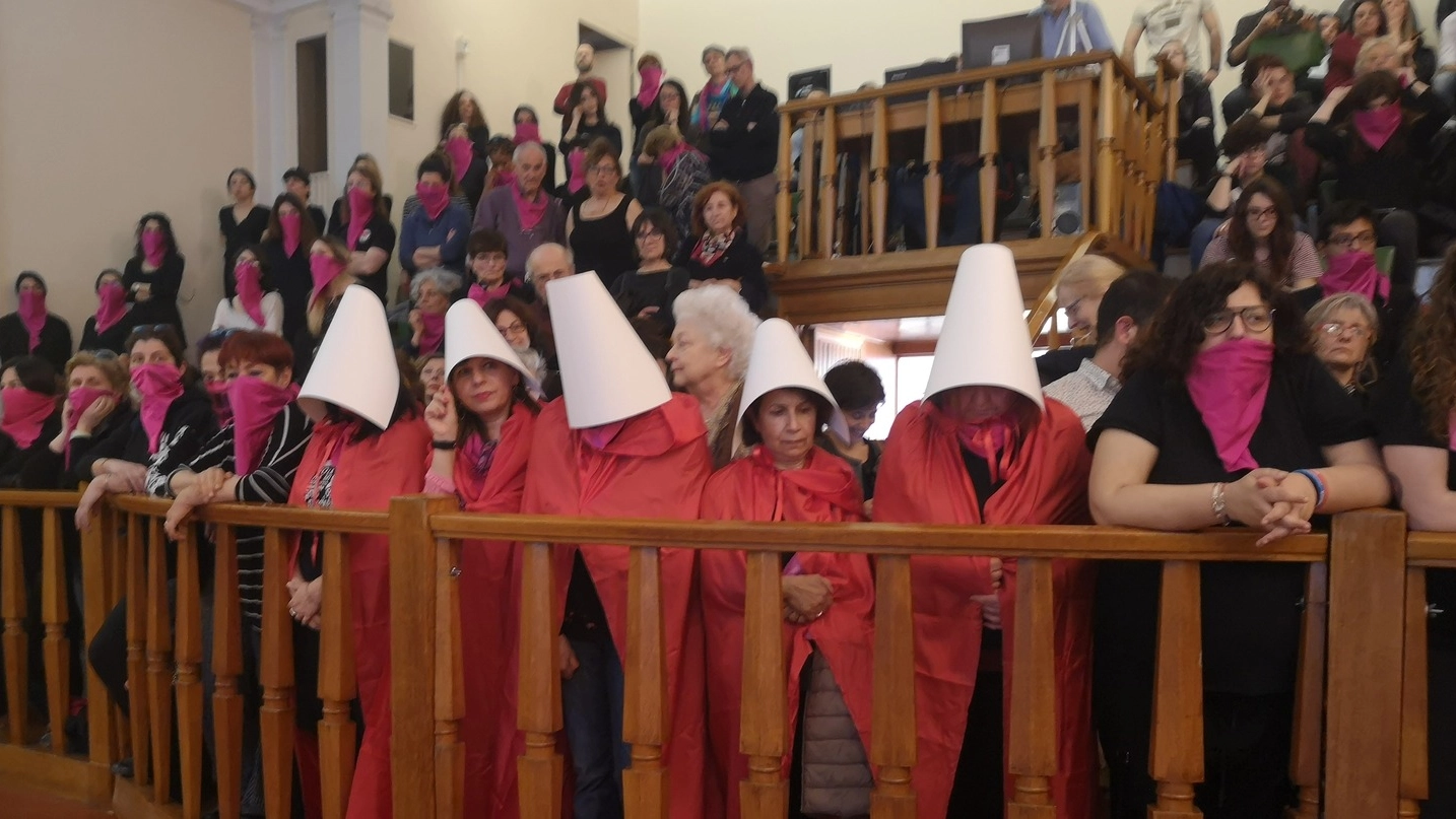 Un gruppo di donne vestite da ‘ancelle’ sulle balconate del Consiglio comunale