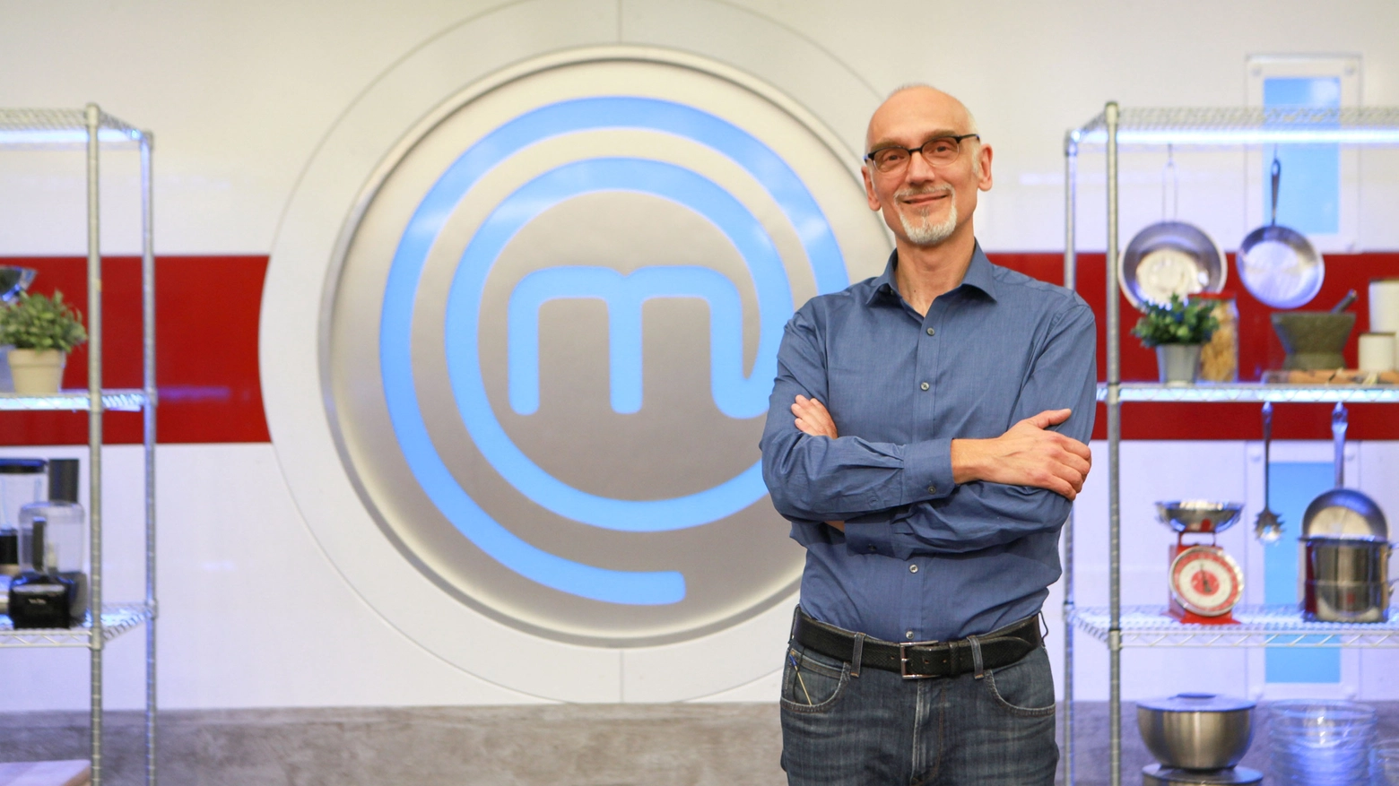 Il bolognese Luca Foletti posa davanti al logo di Masterchef