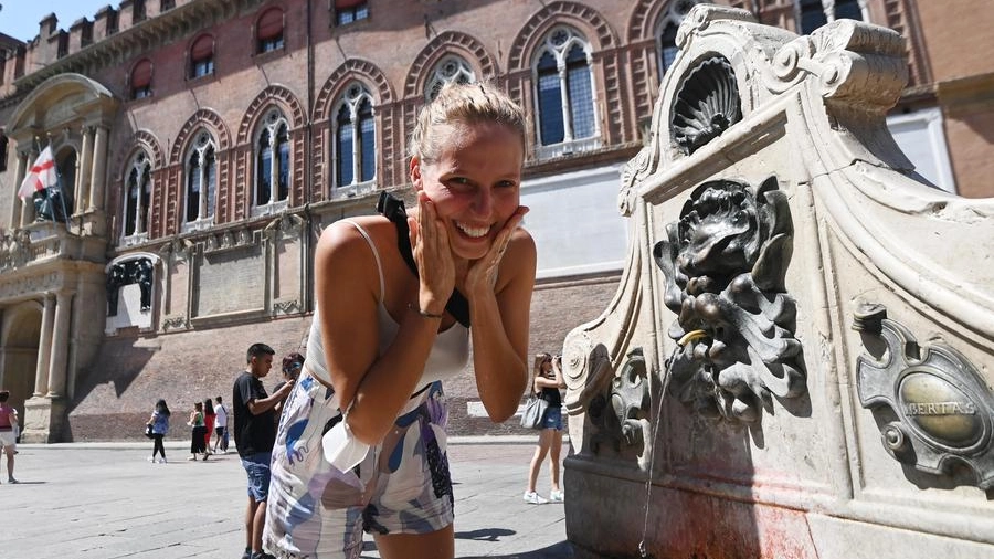  Una turista si rinfresca in Piazza Maggiore