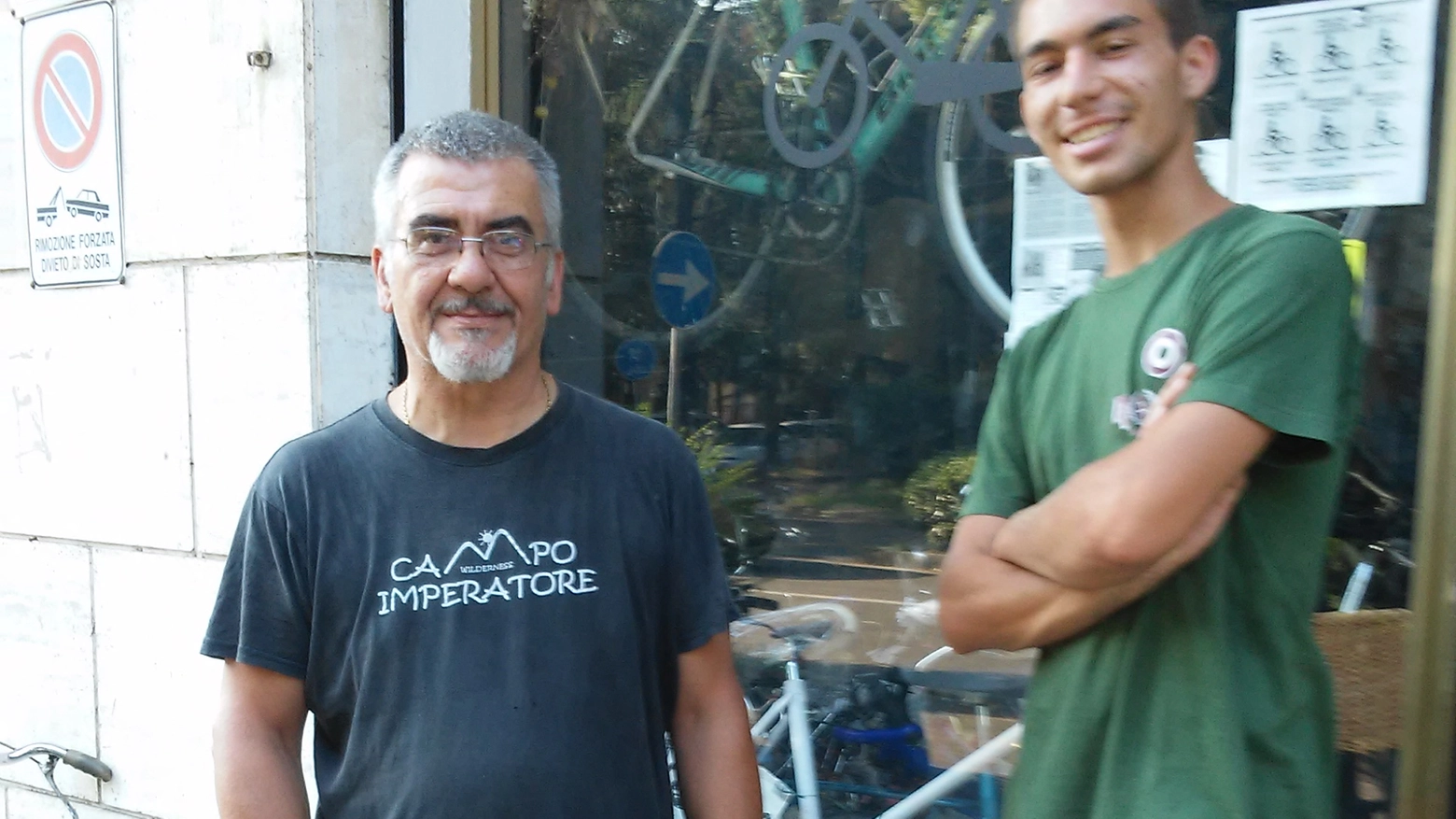 Mauro Corradini  con il figlio Gabriel davanti alla sua bottega «Solo bici» al Gattaglio