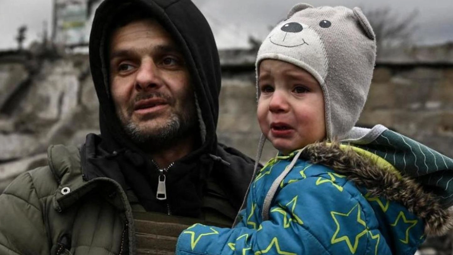 Un uomo e un bimbo in fuga dalla città di Irpin, a Ovest di Kiev