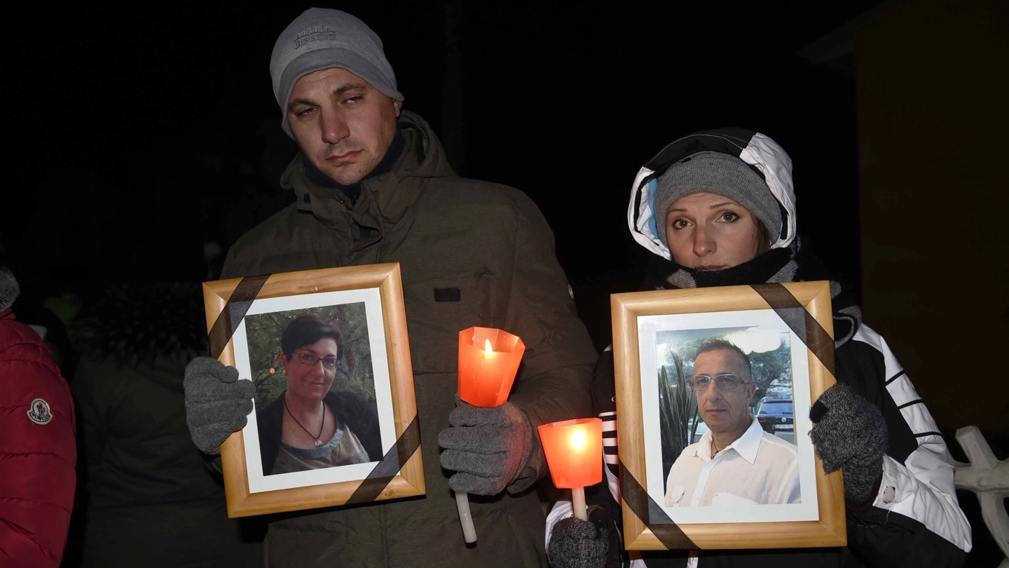 Coniugi uccisi, due partecipanti alla fiaccolata con in mano le foto delle vittime (Bp)