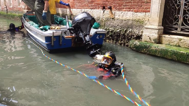 Gondolieri sub ripuliscono i canali a Venezia
