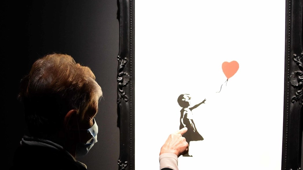 Una visitatrice davanti a Girl with balloon, tra le opere più note di Banksy (foto Bp)