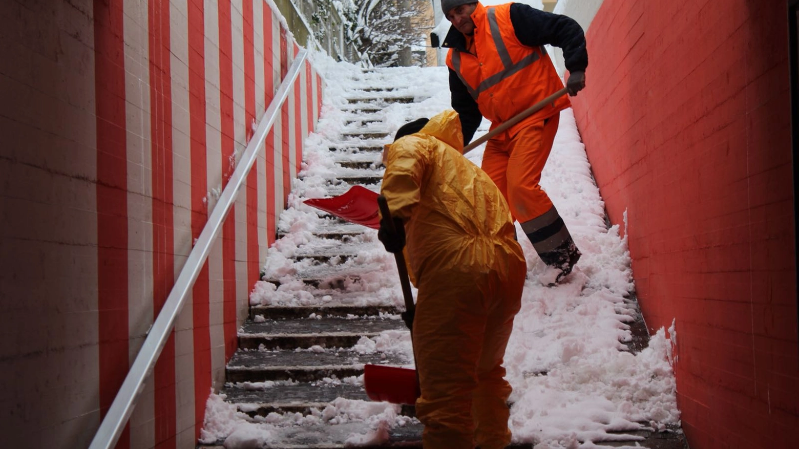 Operai al lavori per liberare i gradini di un sottopasso di Marotta dalla neve