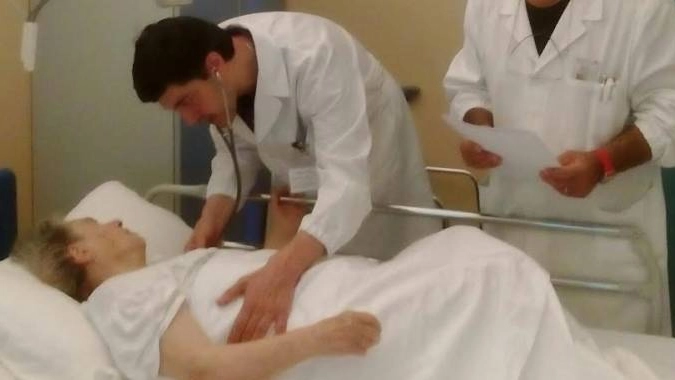 Una donna ferita dal terremoto viene assistita dai medici all'ospedale