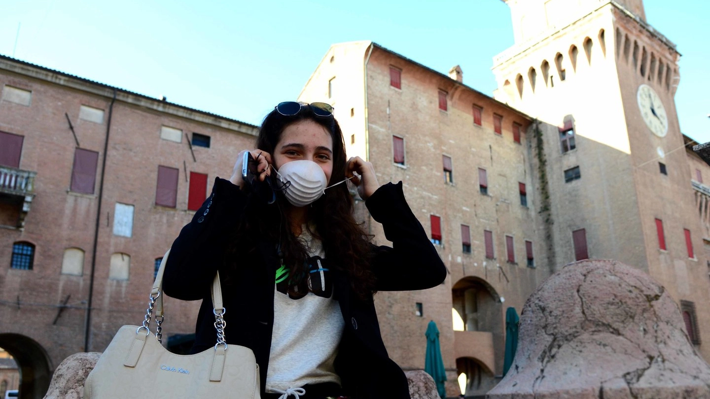 Una ragazza indossa la mascherina in piazza Savonarola