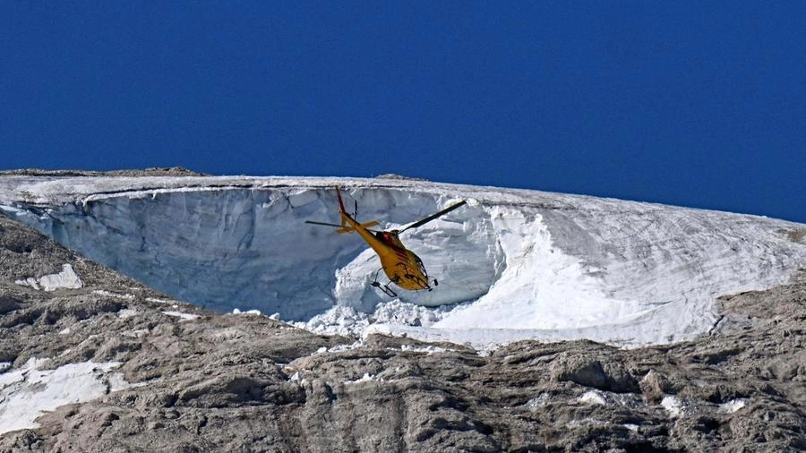 Un elicottero sorvola il punto del crollo sulla Marmolada (Ansa)