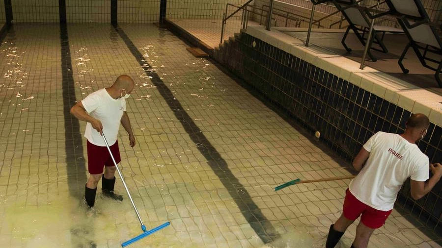 Operatori impegnati per ripulire la grande piscina termale (Foto Marchi)