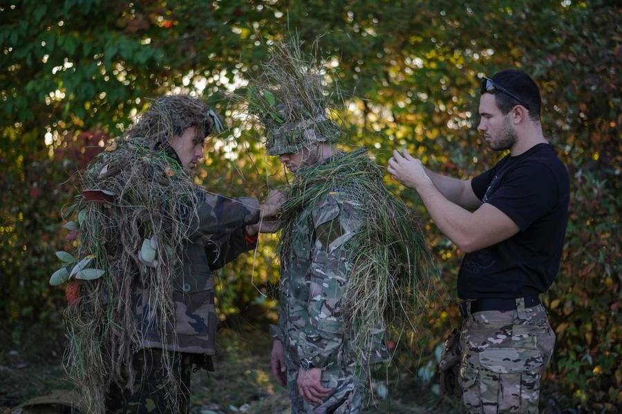 Civili ucraini imparano a mascherarsi durante l'addestramento (Epa)