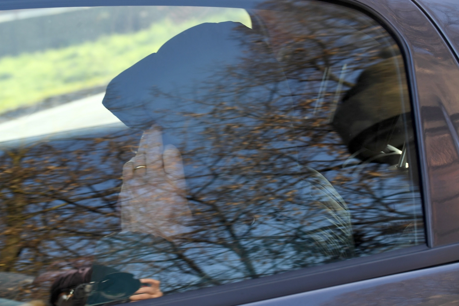 Stefano Natalini si copre il volto sull’auto dei carabinieri che lo porta in caserma