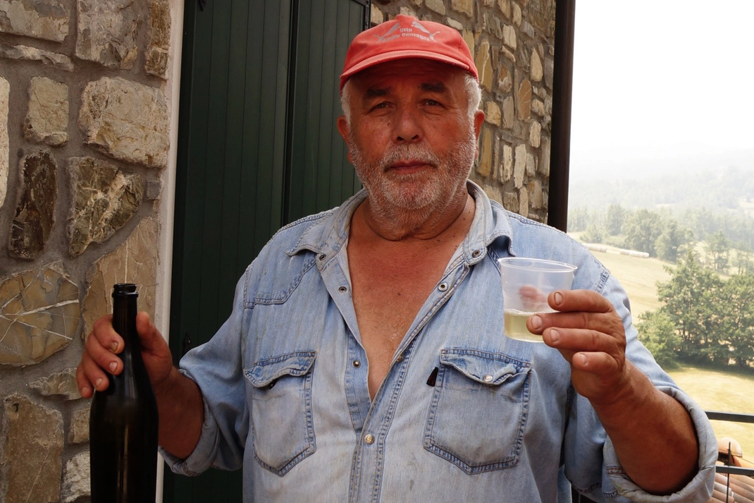 Piero Pini, 70 anni,  brinda assieme  a chi passa dal ‘suo’ paese nel comune di Villa Minozzo