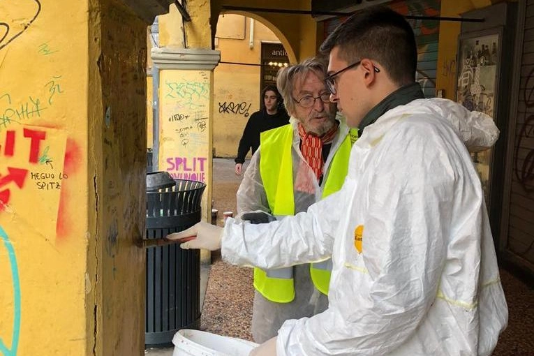 I volontari dei comitati piazza Verdi e via Petroni al lavoro per pulire i muri