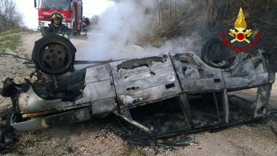 L’auto incendiata nell’incidente di Arcevia. Vigili del fuoco al lavoro