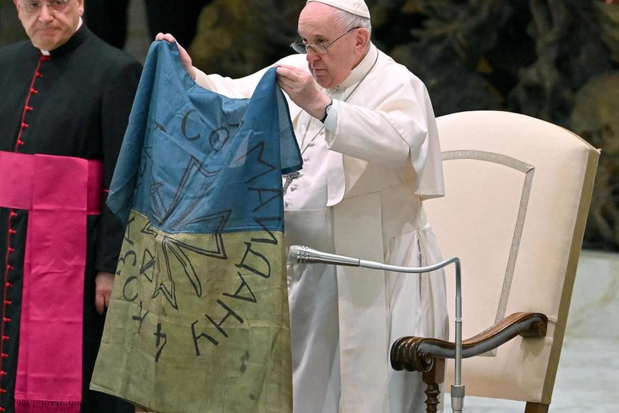 Papa Francesco mostra la bandiera dell'Ucraina ricevuta da Bucha (Ansa)