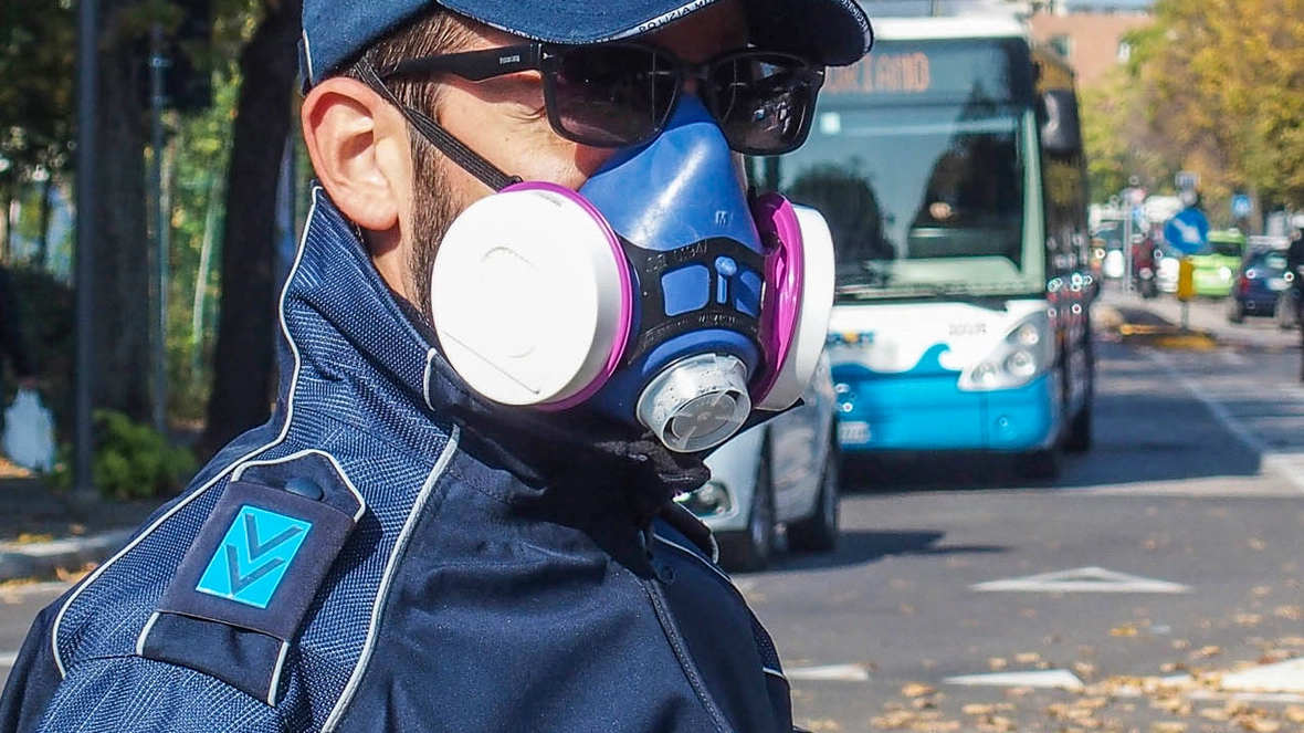 Un vigile urbano mentre dirige il traffico con la maschera antismog: nella giornata di ieri non ci sono state multe per il mancato rispetto dell’ordinanza