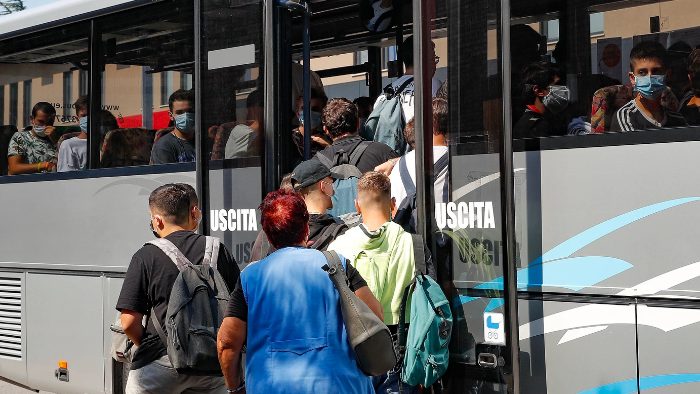 Ragazzi che prendono il bus, all’uscita della scuola, lo scorso settembre (foto archivio)