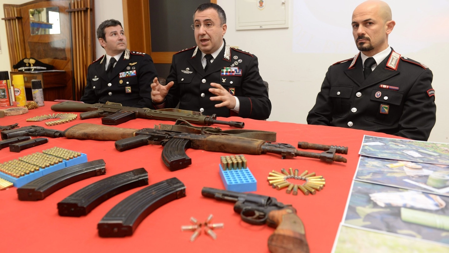 I carabinieri mentre illustrano le armi sequestrate nel bosco a Ginestreto