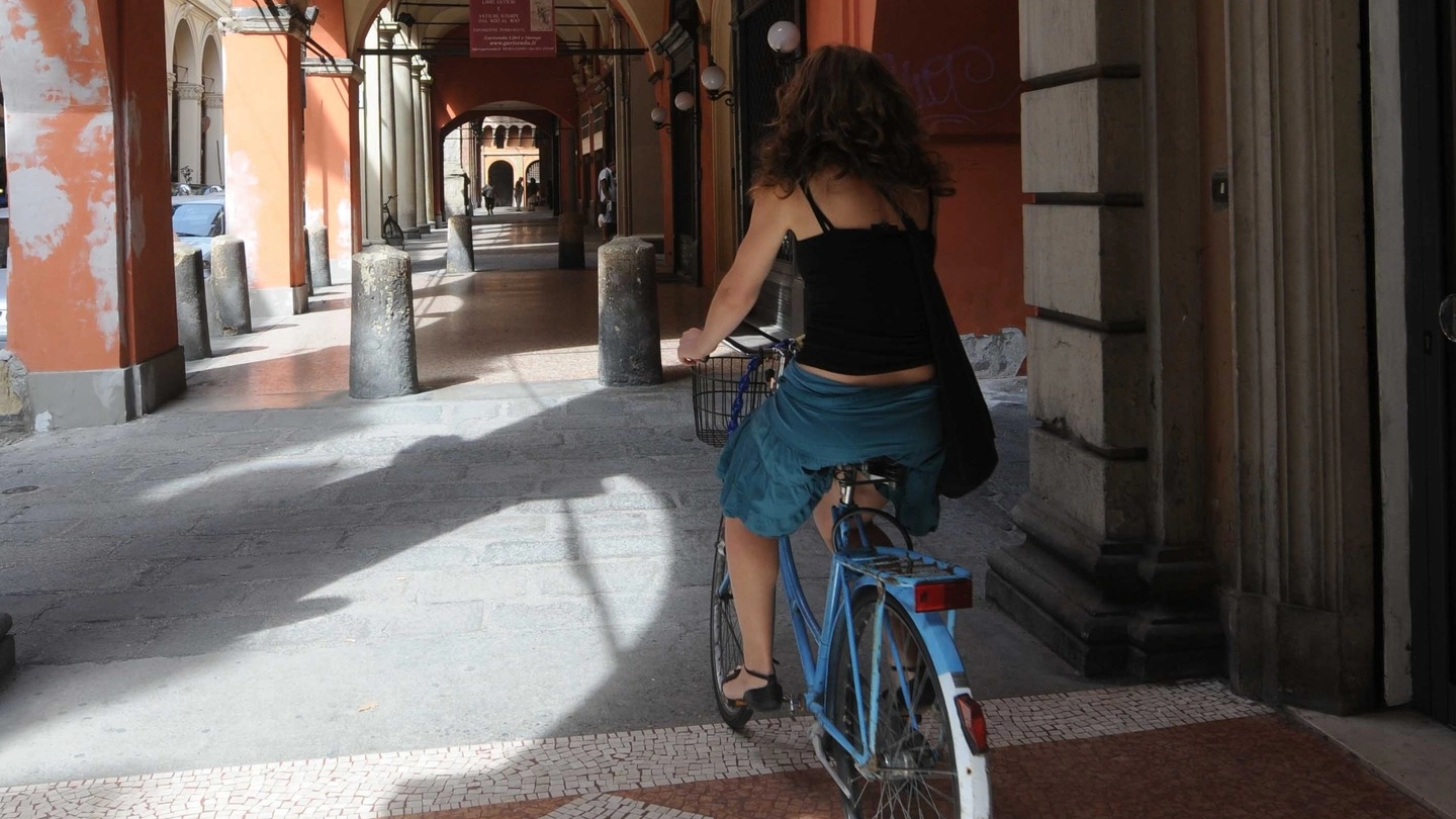 Una ciclista sotto il portico di Strada Maggiore in una foto d’archivio