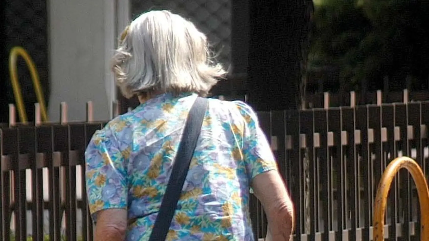 Una donna anziana attraversa la strada