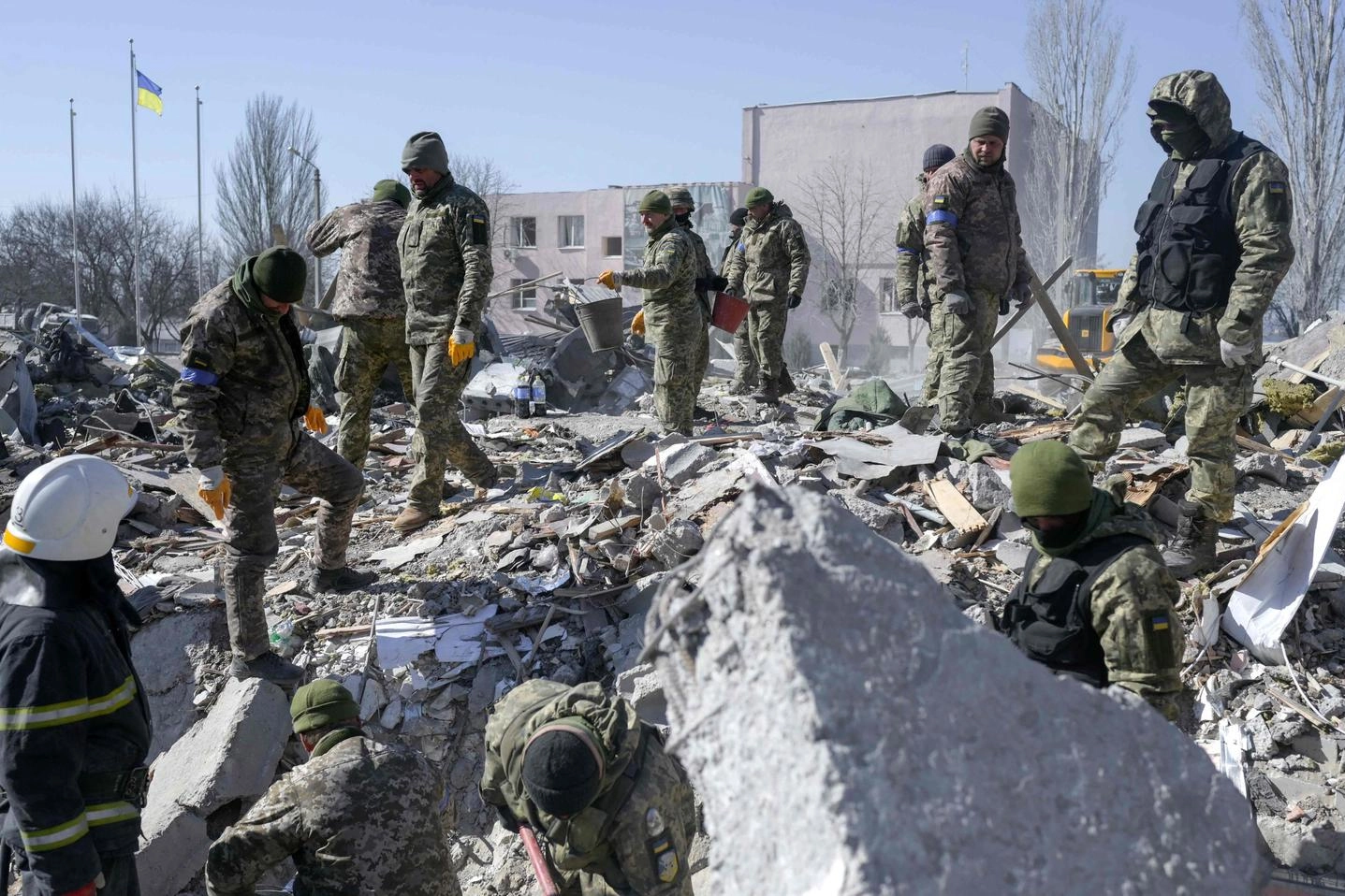 Soldati ucraini scavano tra le macerie della scuola militare di  Mykolaiv