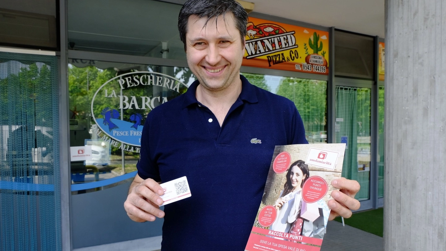Luca Arrigoni con la fidelity card che garantisce punti ai clienti di negozi e botteghe convenzionato (Frasca)