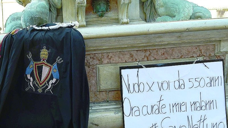 Il mantello della Excelsa Neptuni Balla e il cartello con l’appello ai bolognesi (foto Schicchi)