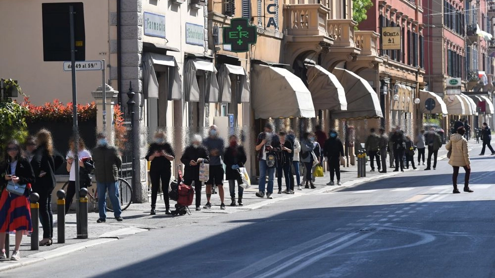 Persone in fila per fare la spesa a Bologna (foto Schicchi)